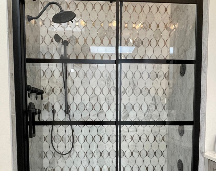 Aall tile on a shower wall with black hardware