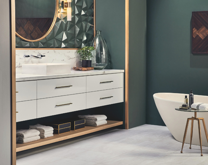 Gray tile flooring in a bathroom with emerald green walls and gold accents